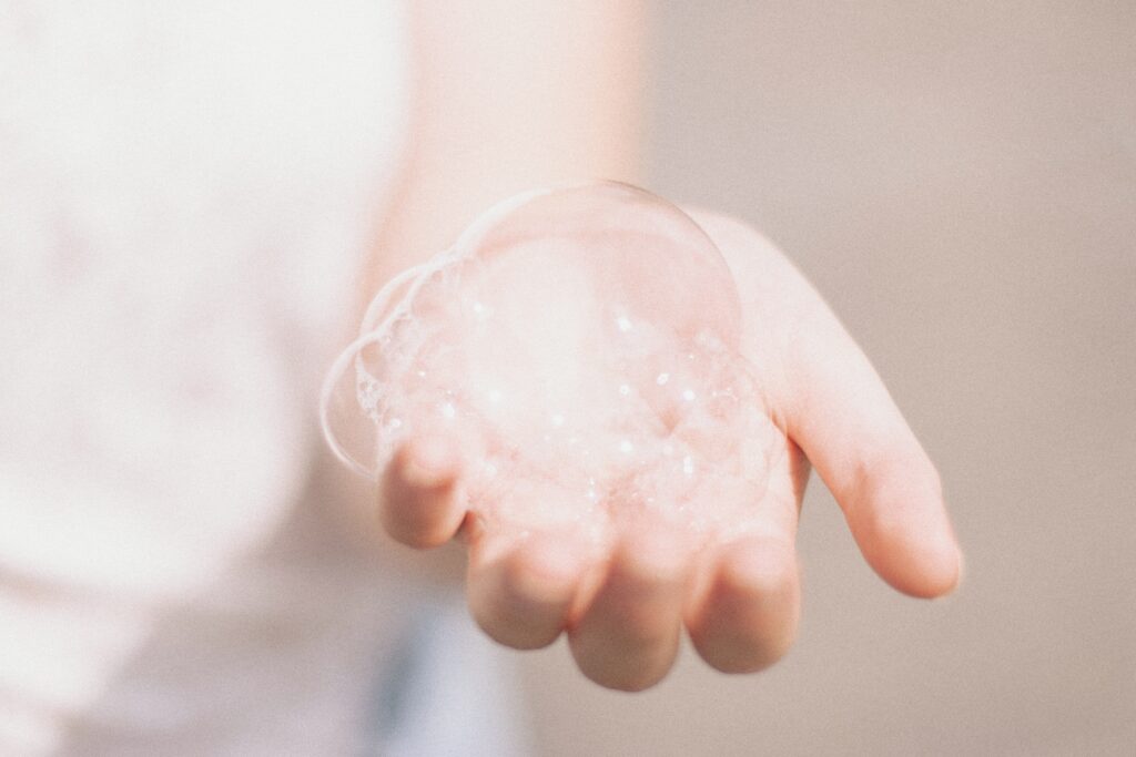 An image of a hand with cleanser bubbles on it